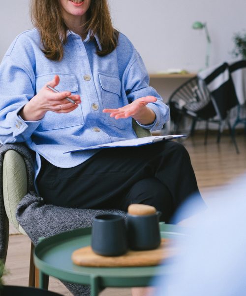 A therapist consults with a client in a contemporary office, focusing on mental health.